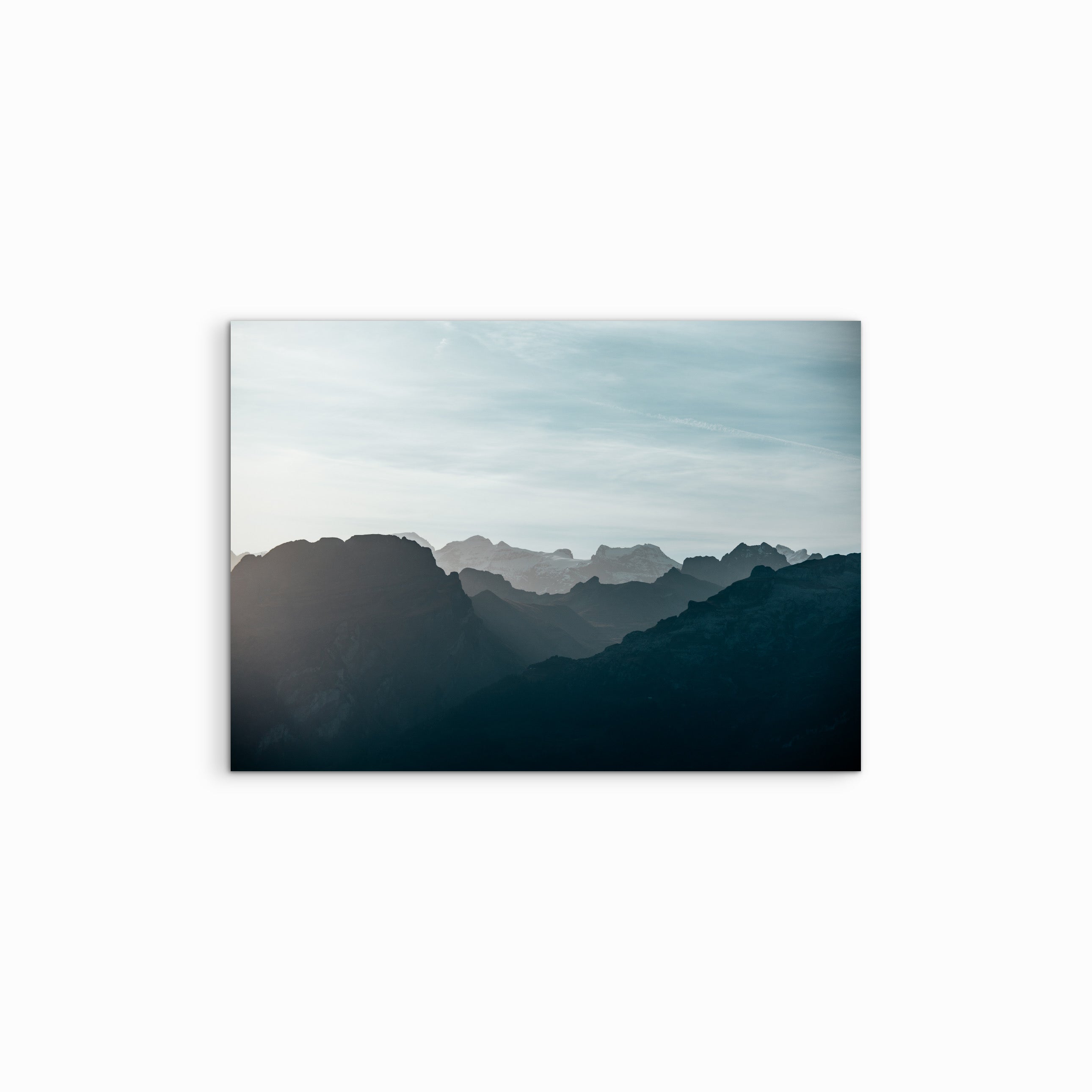Der Fine Art Print "Infinite" hängt vor einem schlichten weissen Hintergrund, die Blue-Hour-Fotografie zeigt eine weitläufige Gebirgsreihe mit vielen, teilweise schneebedeckten Bergspitzen und einem tiefen, dunklen Blaustich.