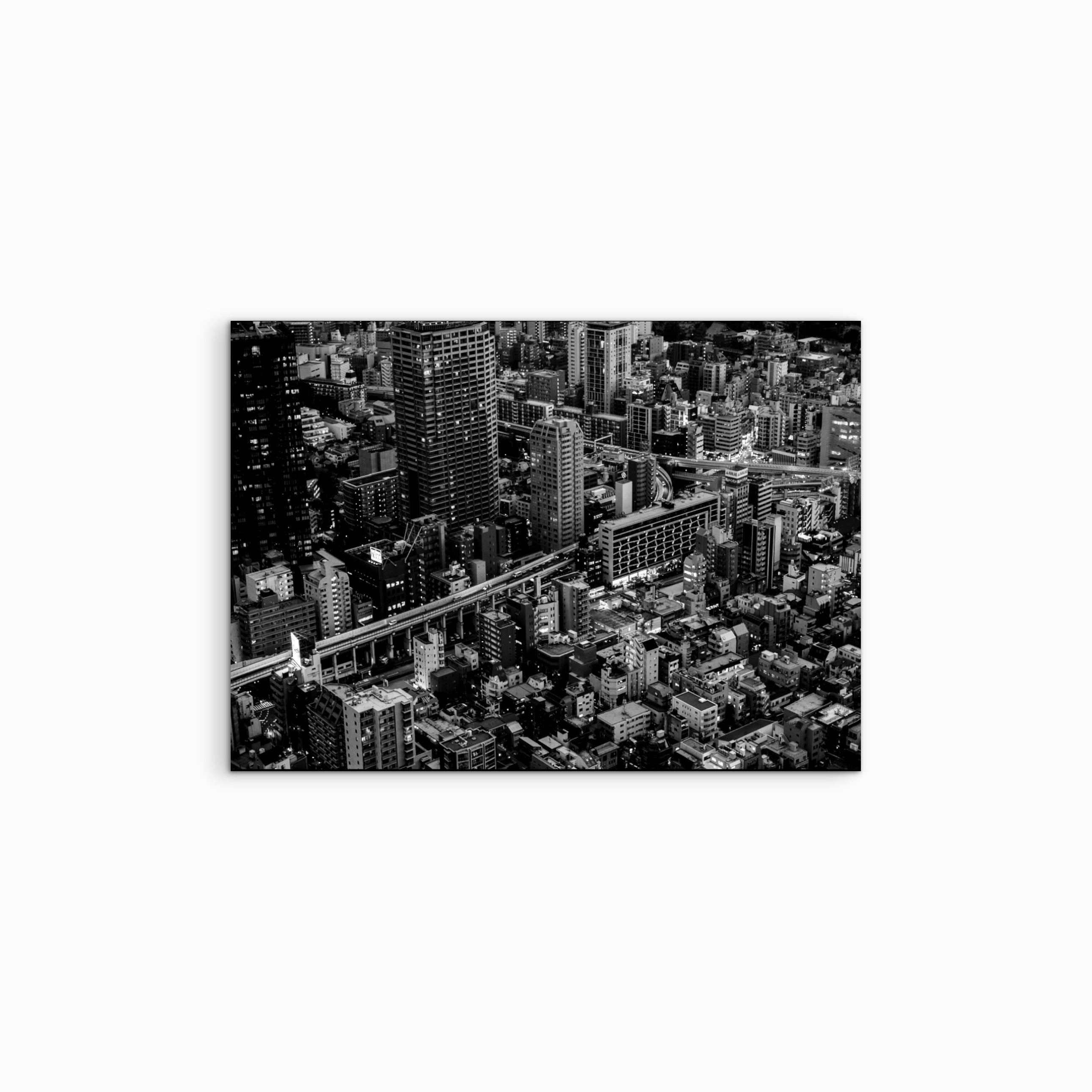 Vor einem weissen Hintergrund kommt der Fine Art Print ‚Neighbourhood‘ besonders zur Geltung, die Schwarz-Weiss-Fotografie zeigt die urbane Tokio-Innenstadt mit kleinen, eng stehenden Häusern und vermittelt eine dichte, atmosphärische City-Stimmung.