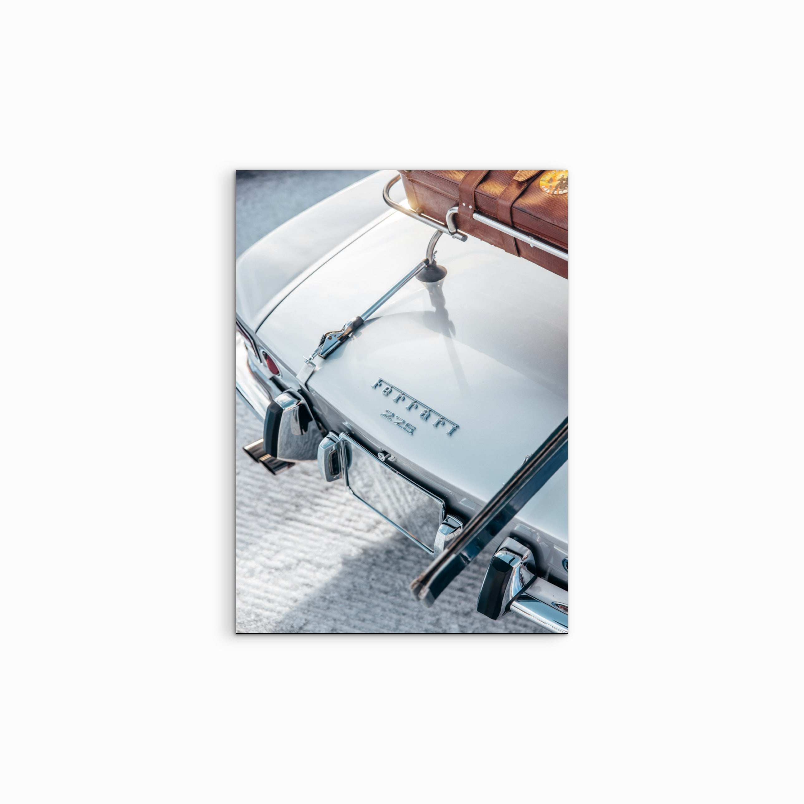 Vor einem weissen Hintergrund präsentiert sich der Fine Art Print „The I.C.E.“, der einen weissen vintage Ferrari 225 mit braunen Retro-Skiern auf dem Dach zeigt, perfekt beleuchtet in einer schneebedeckten Landschaft und ideal für hochwertige Automobil-Fine-Art.
